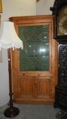 An astragal glazed pine corner cupboard