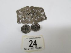 A pair of earring studs in a swirl design and a Victorian floral buckle