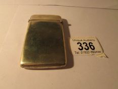 A white metal card case marked with a star and the initials N.S, 8.
