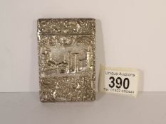An unmarked white metal card case depicting a castle and the Parthenon,
