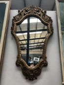 A shield shaped gilt framed mirror