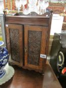 An oak smoker's cabinet with key and tobacco jar