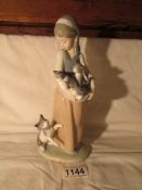 A Lladro figurine of a girl with cat and kittens