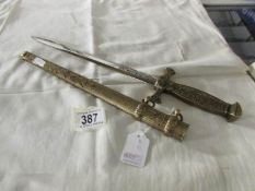 A decorative dagger with brass hilt and scabbard