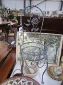 A small wrought iron plant stand in the shape of a chair
