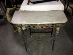 A marble topped table on brass plated base