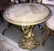 A gilded table the top supported by cherubs