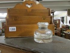 An oak stationery rack and a glass inkwell