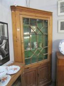 A large glazed pine corner cupboard