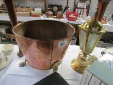 A copper pot and a brass lantern style table lamp