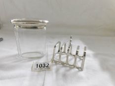 A silver toast rack by Adie Brothers, Birmingham 1933/34 and a silver topped dressing table jar H.A.