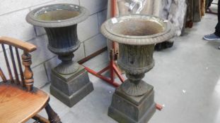A pair of Victorian cast iron garden urns,