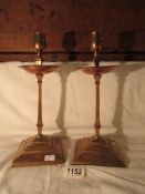 A pair of arts and crafts brass and copper candlesticks by W.A.S.