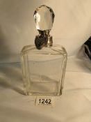 A glass liquor decanter with silver collar hall marked Birmingham 1908 and a silver plated padlock