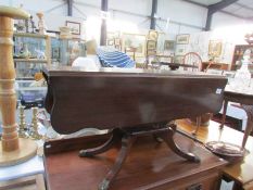 A long and low mahogany drop leaf table