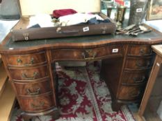 A good 20th century serpentine front kneehole desk with leather inset top, 4 drawers on either side,
