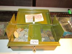 A metal cast box with key containing old coins and a 10/- note