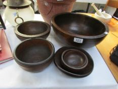 A large wooden bowl and 5 smaller examples