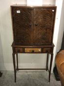 A mid 20th century cocktail cabinet with flame mahogany doors