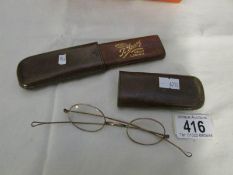 A pair of vintage spectacles (possibly gold rimmed) with leather case