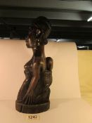 A carved rosewood tribal figure being a woman carrying her baby on her back
