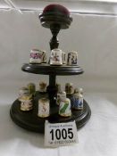 15 Royal Crown Derby thimbles on stand with pin cushion top