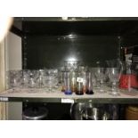 A shelf of assorted glass ware