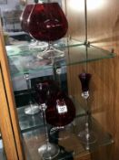 2 red glass brandy goblets and a pair of coloured glass candle holders