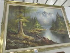 A gilt framed lake and mountain scene