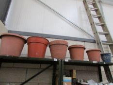 A terracotta garden pot and a quantity of plastic garden pots