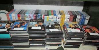 A shelf of DVD's including approximately 40 TV series box sets and over 50 James Bond etc