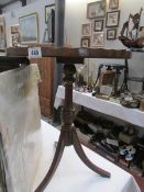 A leather topped tripod wine table