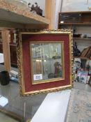 A gilt and velvet framed mirror