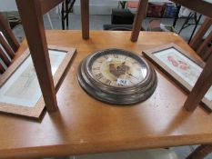 A circular clock and a pair of prints