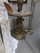 An antique gilded table on cherub base