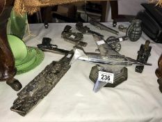 A collection of military themed lighters including aircraft carrier, fighter jet, cannon & guns etc.