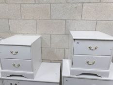 A pair of white bedside chests