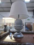 A table lamp in the shape of a pine cone complete with shade