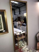 A long gilt framed mirror