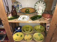 2 shelves of painted teracotta/stoneware bowls etc.