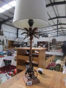 A table lamp in the shape of a palm tree complete with shade