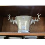 A white metal ice bucket with stag head handles