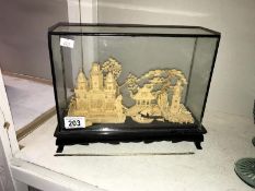 A cork model of temples & trees in glass cabinet