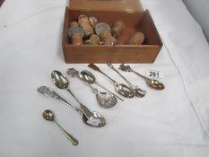A collection of old corks with coins in tops and 7 collector's spoons