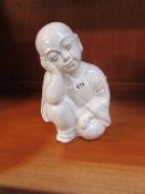 A ceramic figure of a Chinese boy