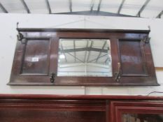 An oak coat rack with bevel edged mirror