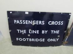A railway sign 'Passengers Cross Here'