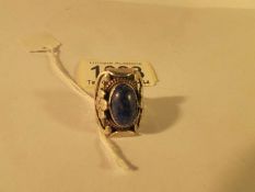 A Lapis-Lazuli set ring in silver with unusual flowers to shoulders