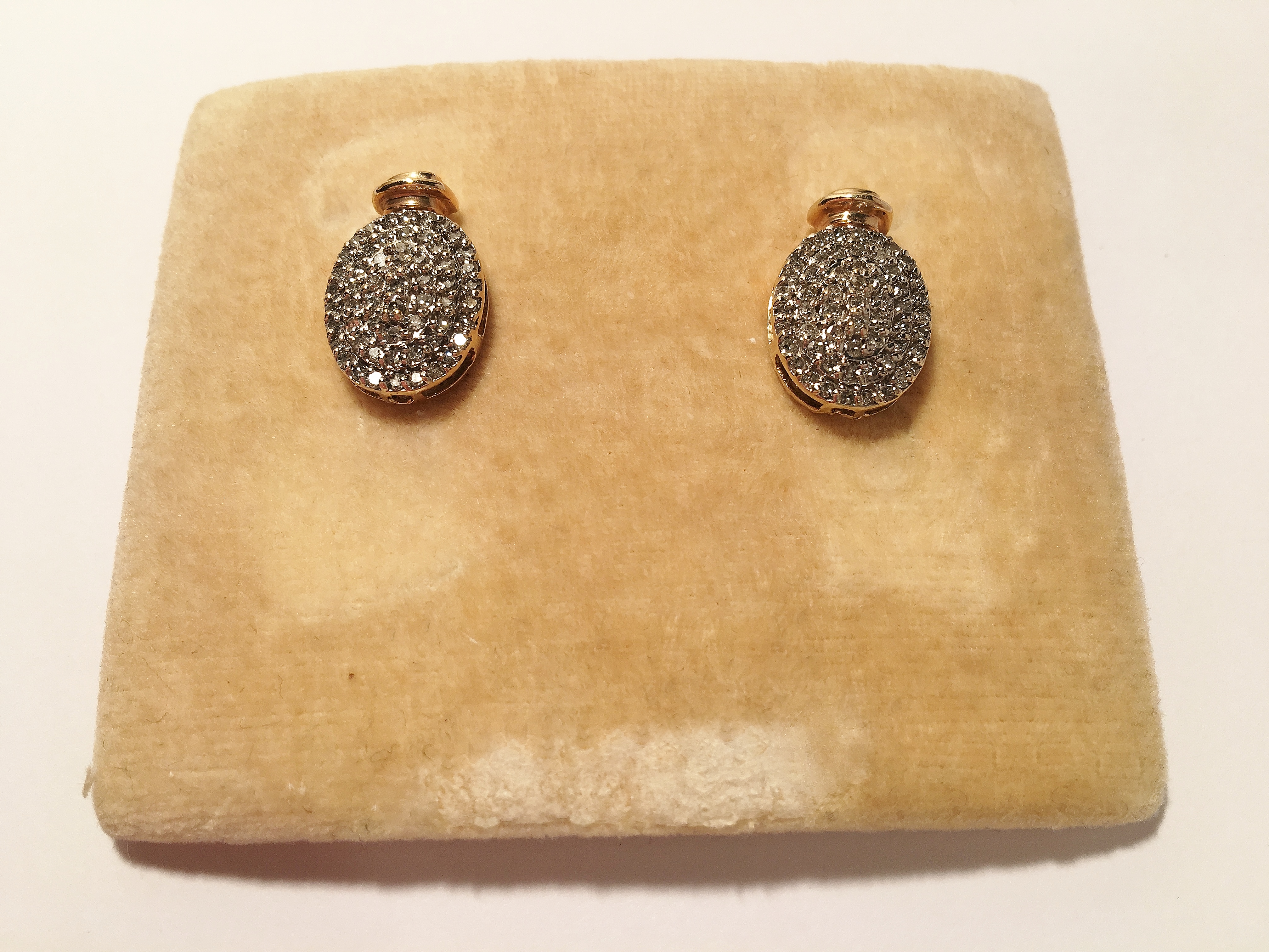A pair of 2 tone gold oval diamond earrings