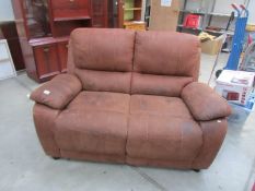 A tan 2 seat leather sofa.